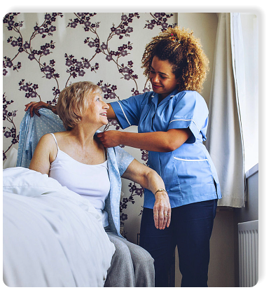 Home Caregiver helping a senior woman get dressed