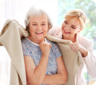 Caregiver covering senior woman with plaid at home