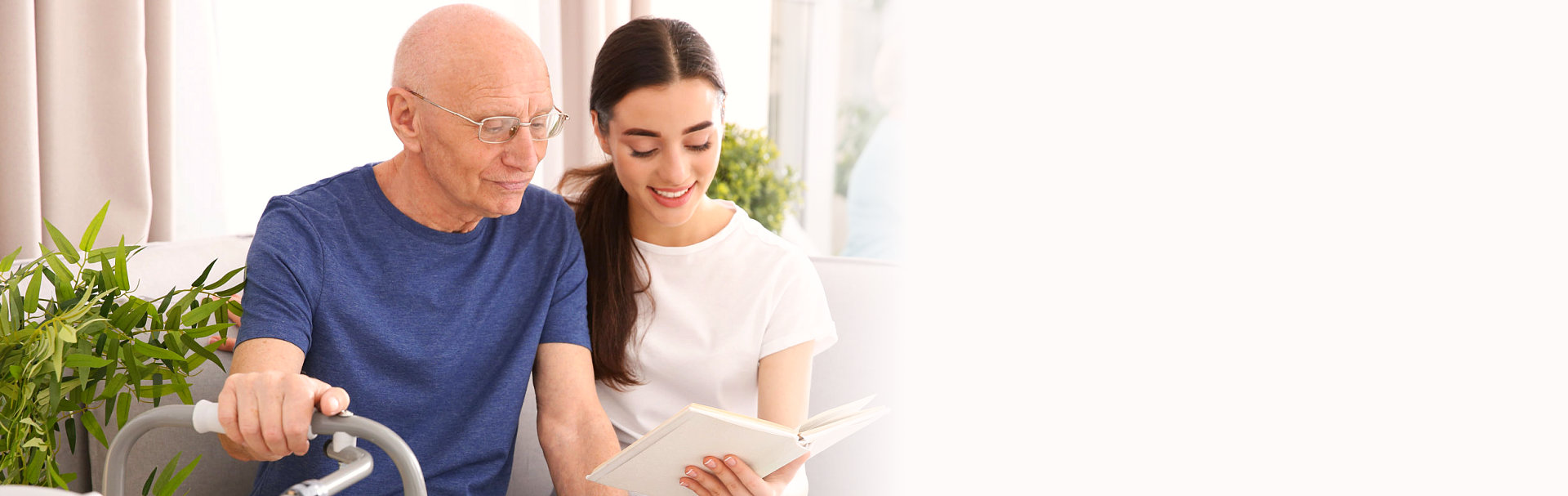 Senior man with young caregiver at home
