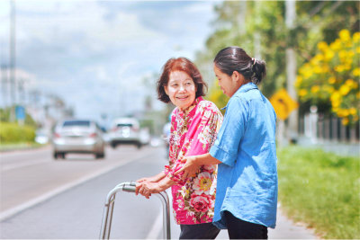 Senior woman using a walker crossing the street